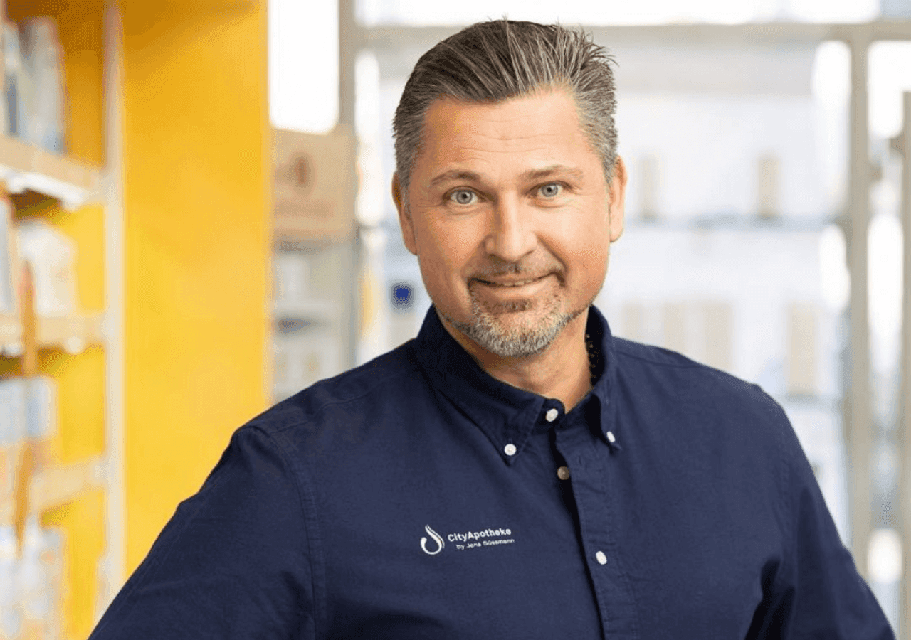 Jens Süßmann im Hintergrund die Apotheke